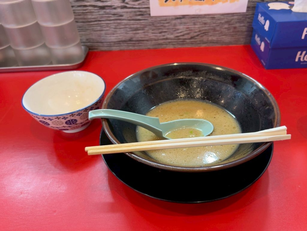 alt="ラーメンを完食した後の器と食べ終わったライス茶碗(横浜家系ラーメン白金家・筆者撮影)"