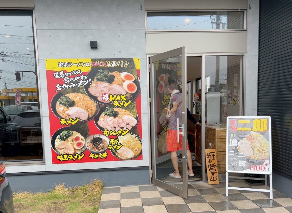 alt="横浜家系ラーメン白金家 浜線バイパス店の入口付近にある写真付きメニュー看板(筆者撮影)"